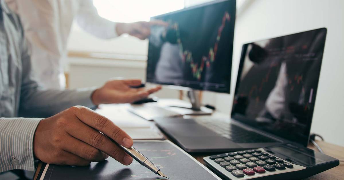 Risico analyse: close-up van 2 mannen welke data en grafieken aan het bekijken zijn op een laptop en beeldscherm